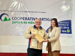 Richard Núñez recibiendo de la gerencia de Cooperativa Artigas los premios que fueron donados para sortear.